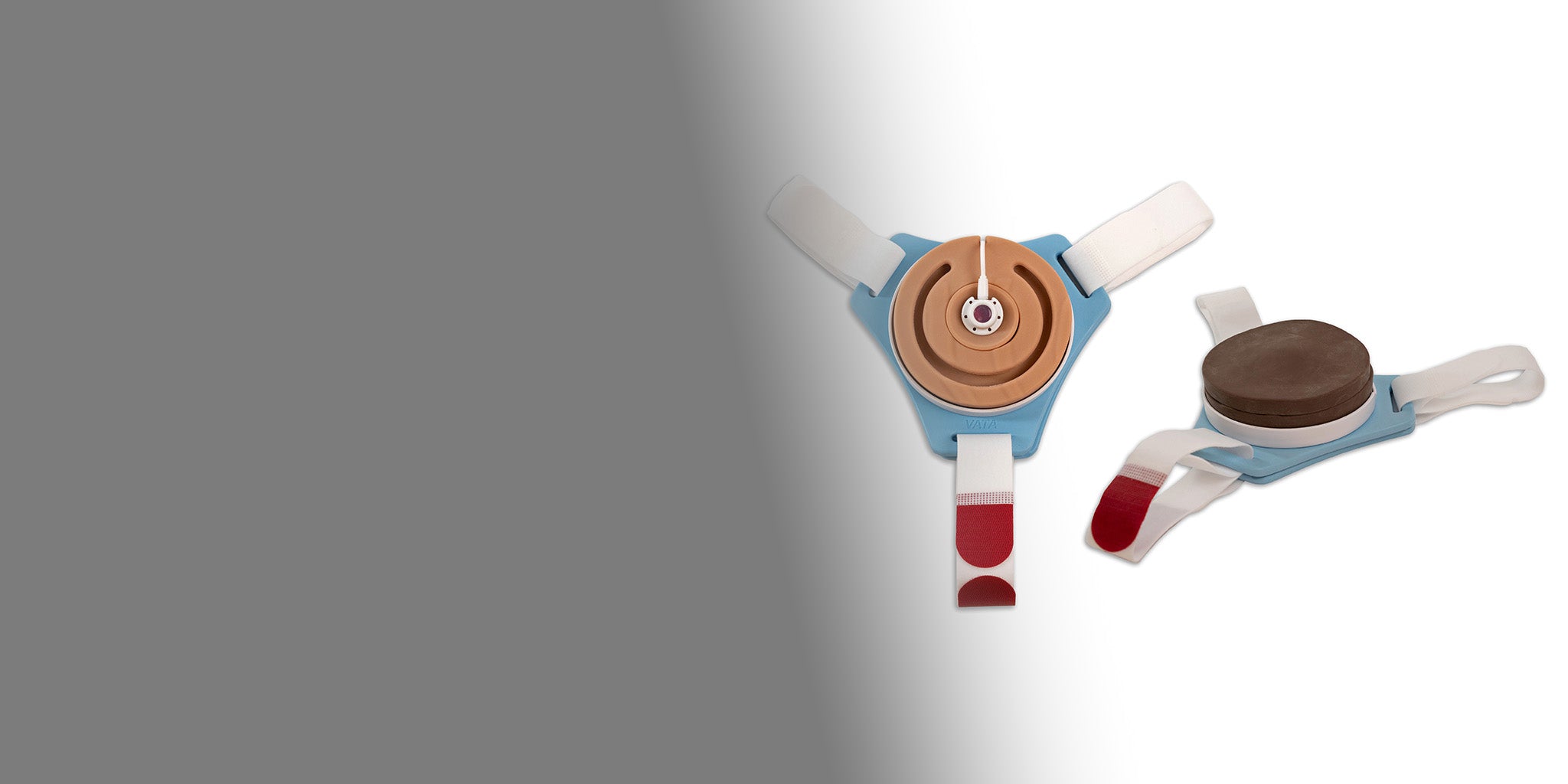 Two Wearable Port Access Trainers, one in the light and the other dark skin pigment option.